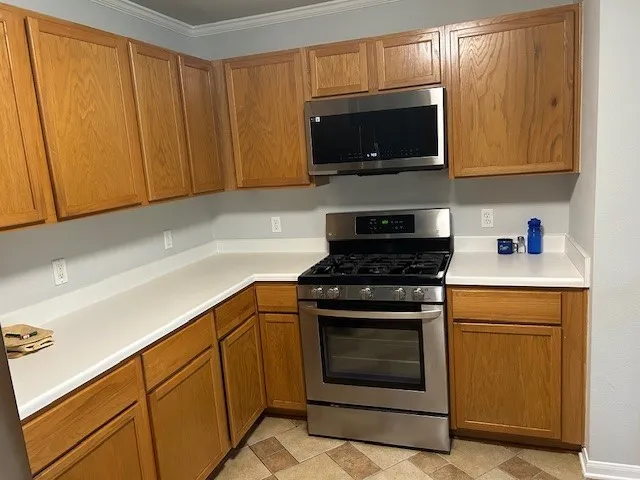 a kitchen with stainless steel appliances a stove a microwave sink and cabinets
