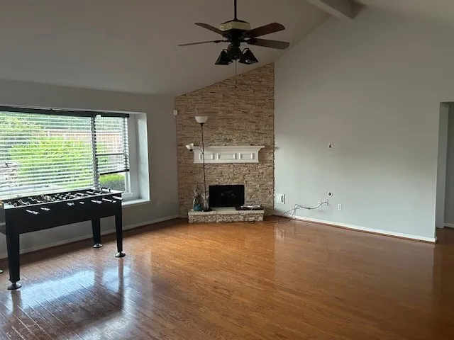 a view of a livingroom with furniture a fireplace and wooden floor