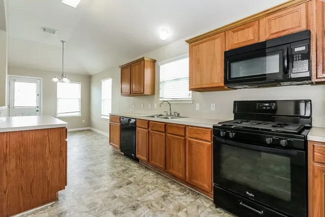 a kitchen with stainless steel appliances a stove a microwave a sink and a microwave