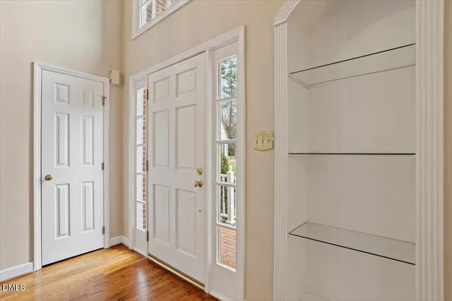 an empty room with windows and ceiling fan