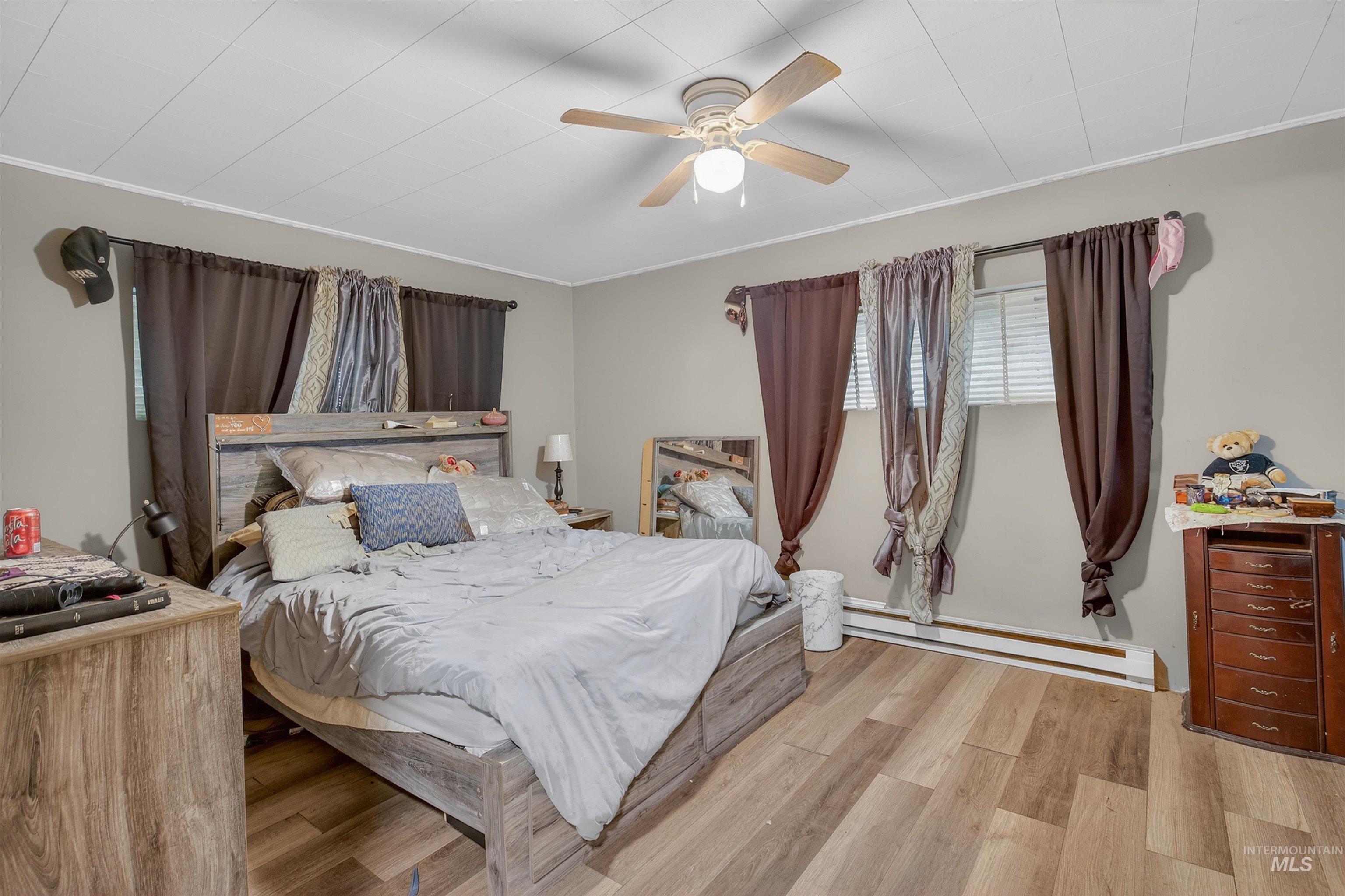 307 Esther Street Kooskia, ID 83539 - Photo 10 of 37 Bedroom with a baseboard radiator, light wood finished floors, ceiling fan, and ornamental molding
