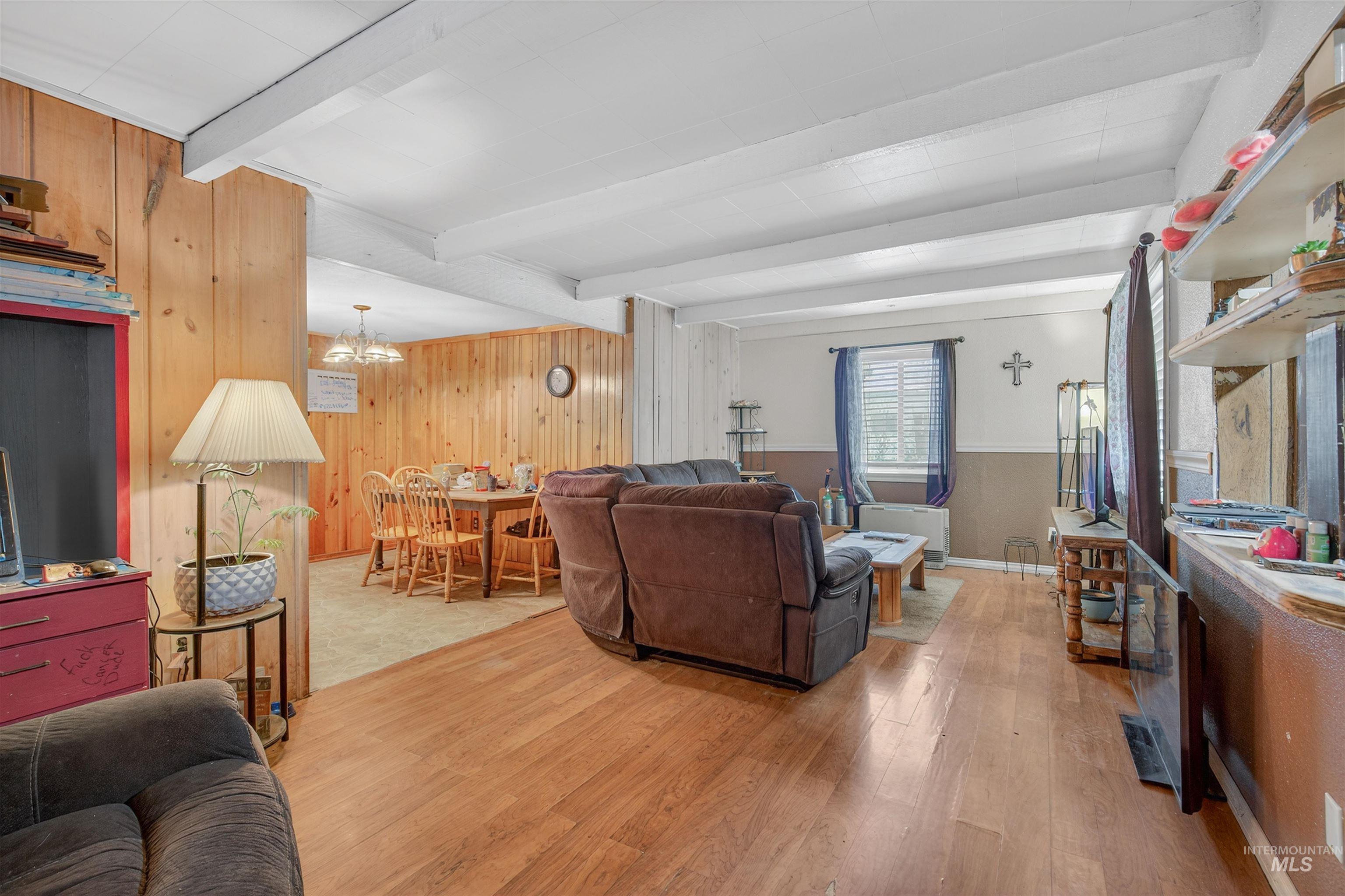 307 Esther Street Kooskia, ID 83539 - Photo 4 of 37 Living room with light wood-style floors, wooden walls, a chandelier, and beamed ceiling