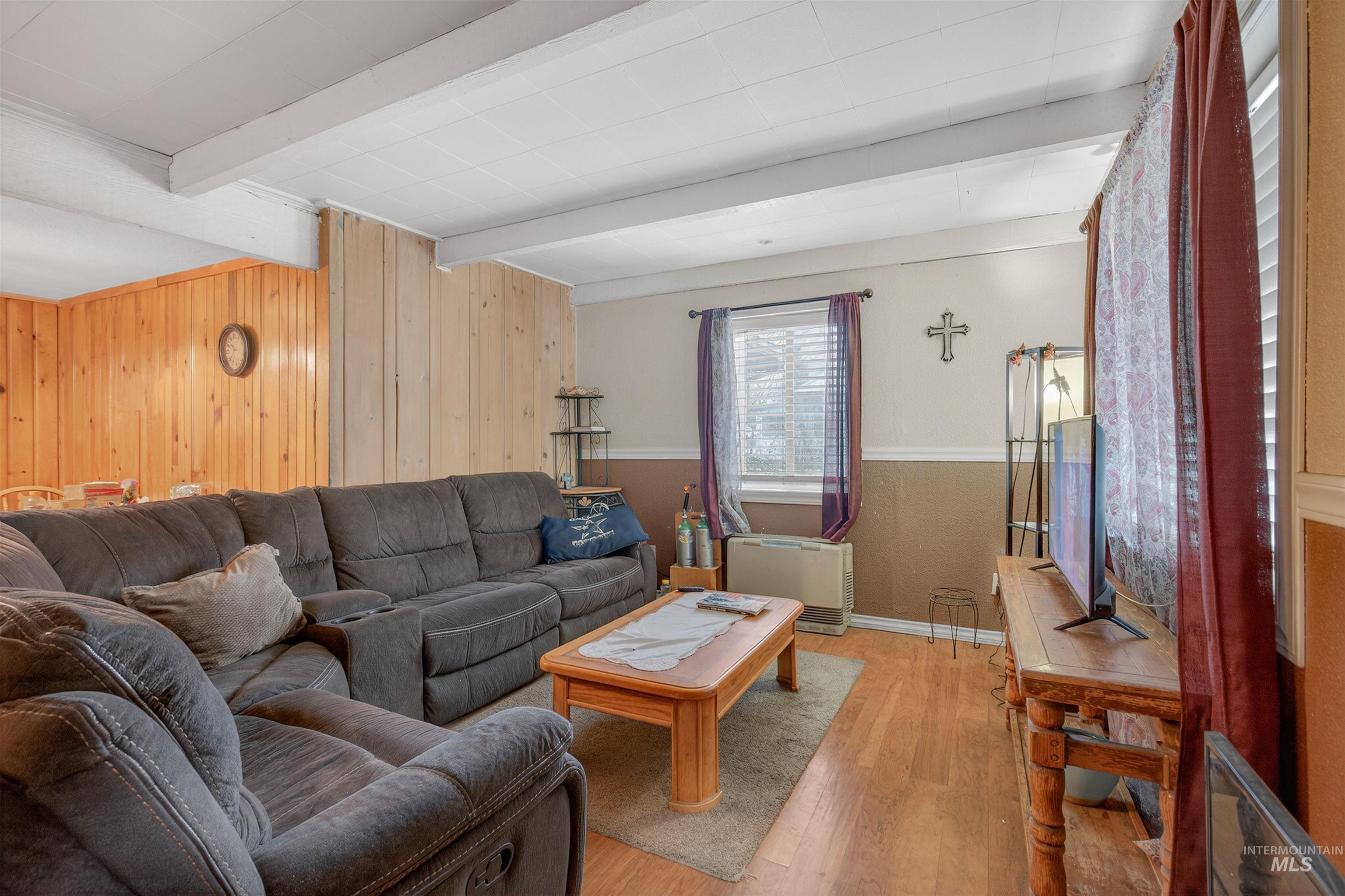 307 Esther Street Kooskia, ID 83539 - Photo 5 of 37 Living area featuring wood finished floors, wooden walls, and beamed ceiling