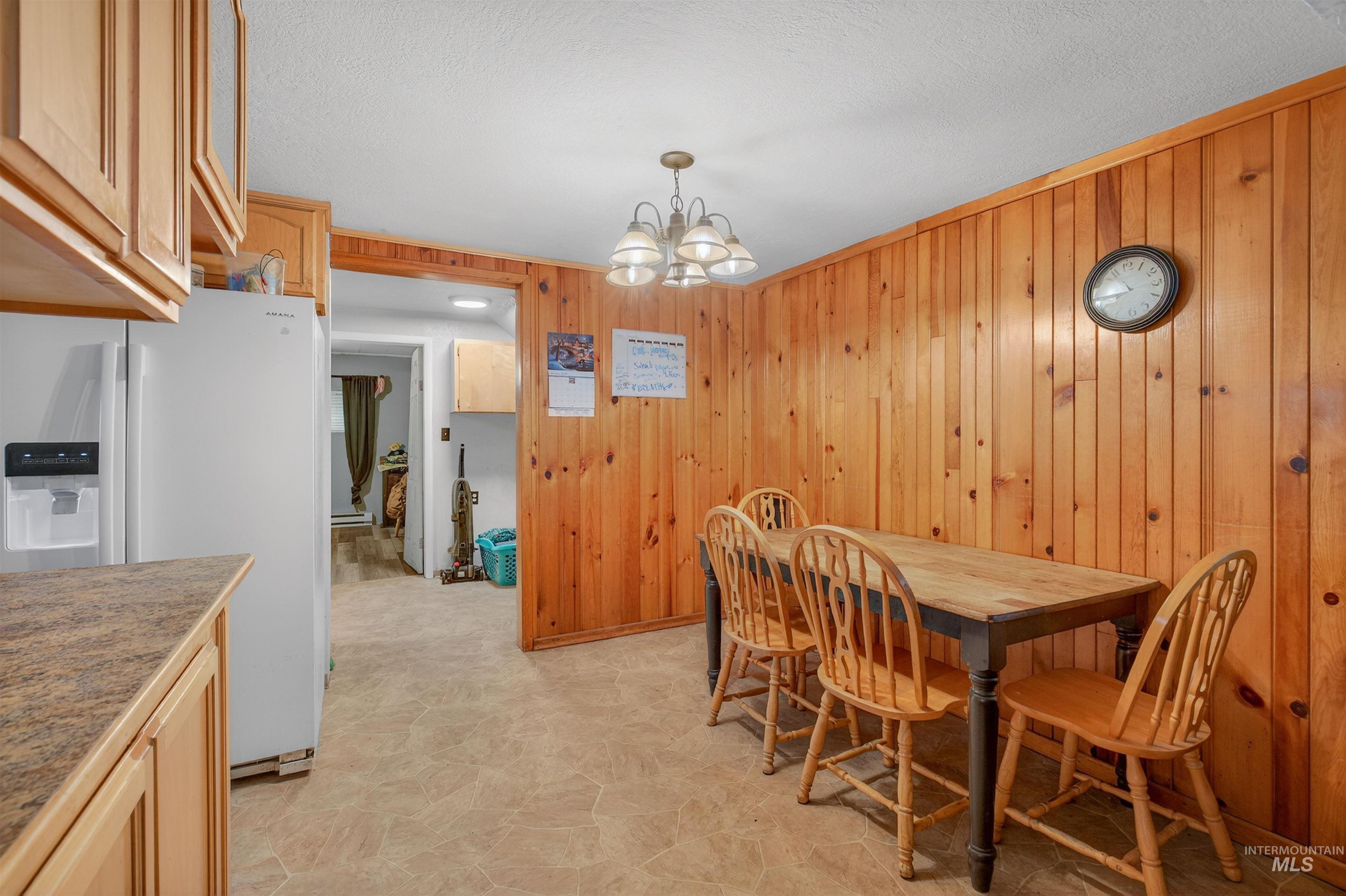 307 Esther Street Kooskia, ID 83539 - Photo 6 of 37 Dining room with a chandelier and wood walls
