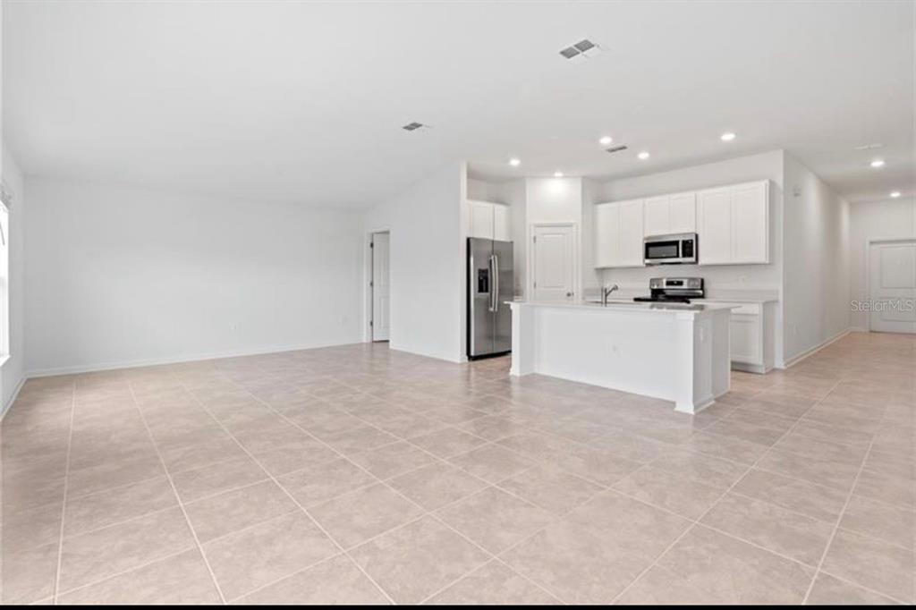 352 Heroic Road Davenport, FL 33837 - Photo 5 of 19 a view of a kitchen with refrigerator and a fireplace
