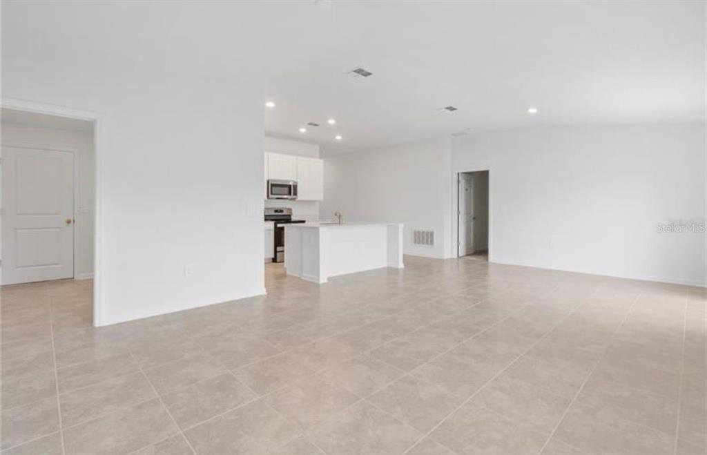 352 Heroic Road Davenport, FL 33837 - Photo 6 of 19 a view of a kitchen with a refrigerator and a microwave