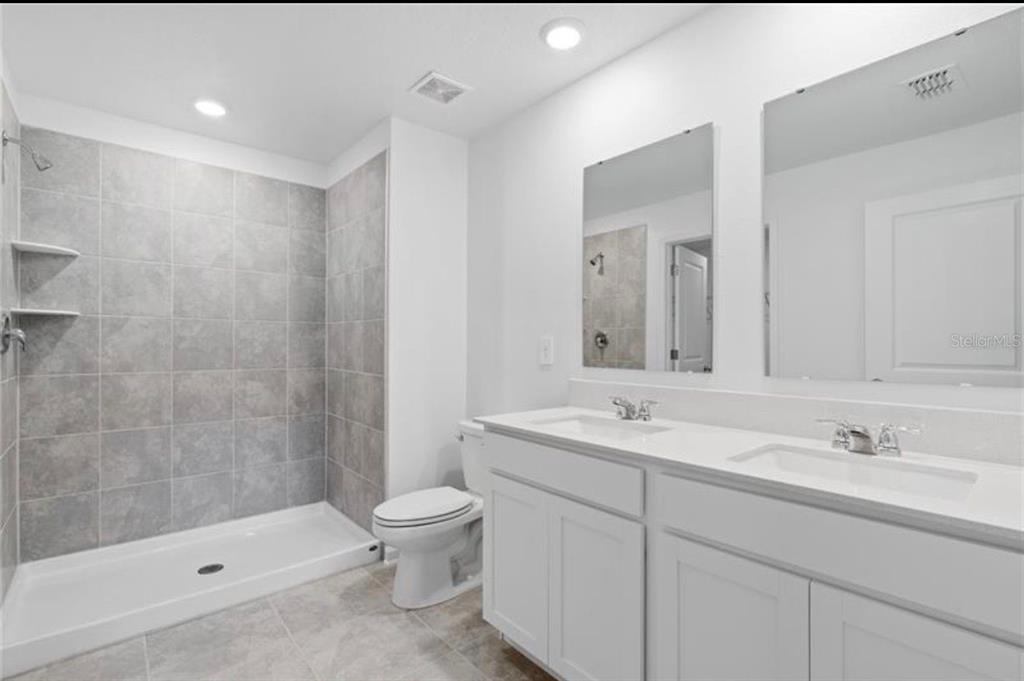 352 Heroic Road Davenport, FL 33837 - Photo 8 of 19 a bathroom with a sink a toilet and shower