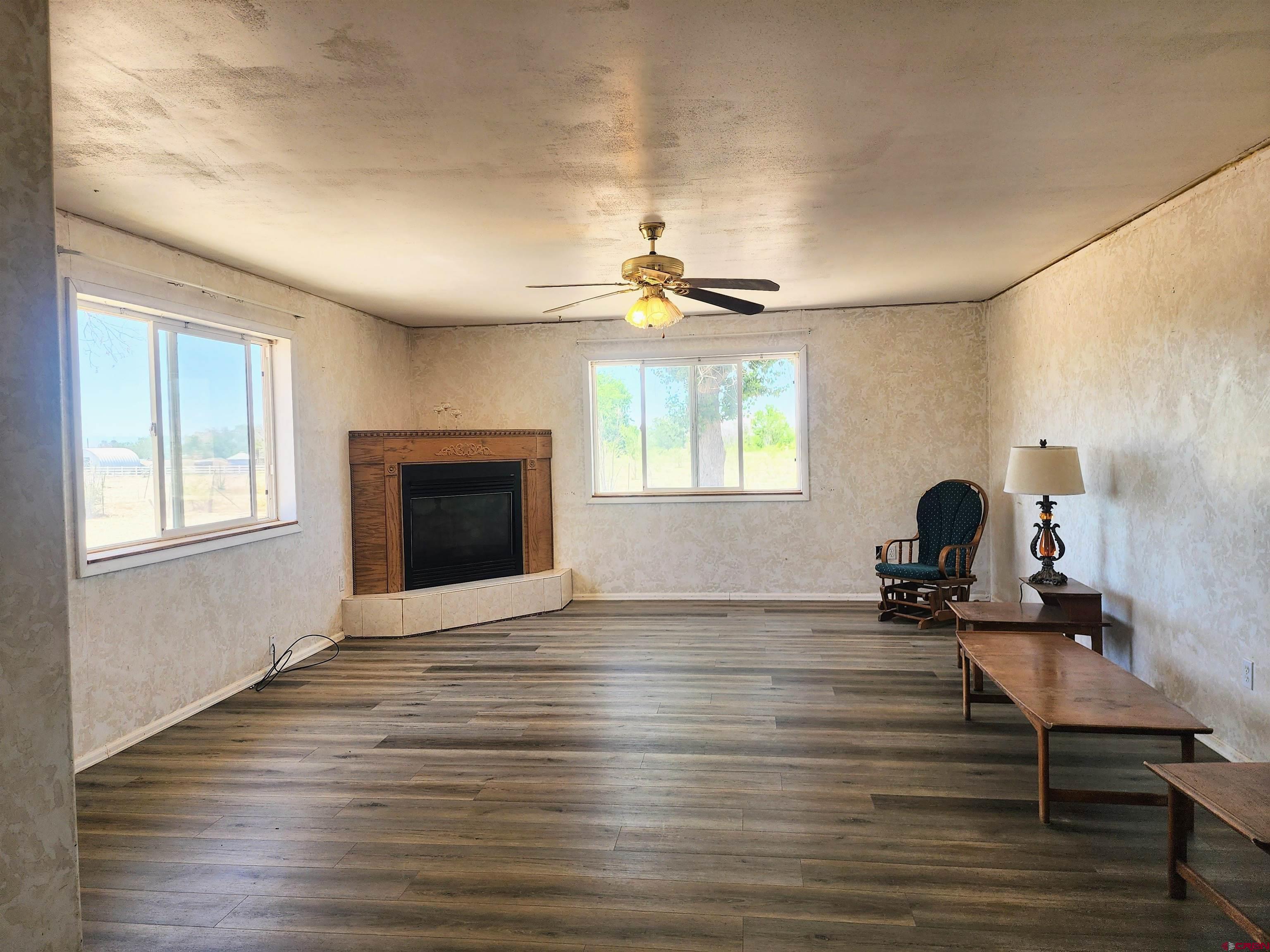 20897 Iris Road Austin, CO 81410 - Photo 7 of 29 a view of a livingroom with a fireplace a window and a wooden floor