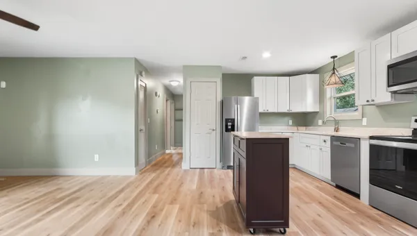 a kitchen with a refrigerator and a stove top oven