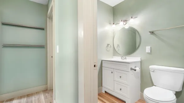 a bathroom with a toilet a sink a mirror and vanity