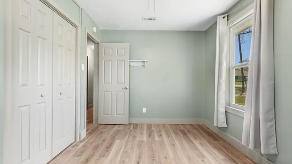a view of a room with wooden floor and a window