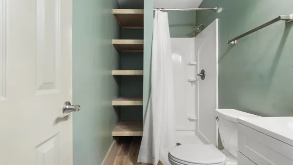 a bathroom with a toilet and a shower