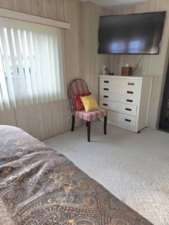 a view of a bedroom with furniture and a flat screen tv