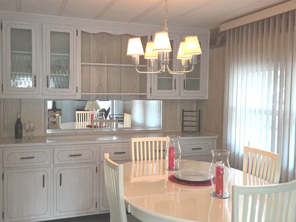 a kitchen with white cabinets and window