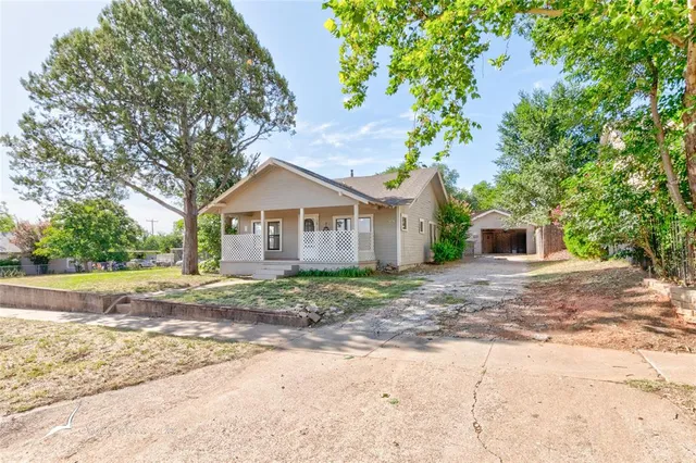 a front view of a house with a yard and trees
