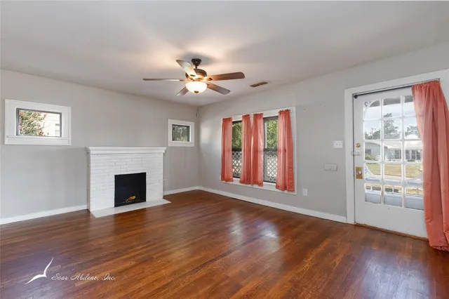 a view of an empty room with a fireplace and a window