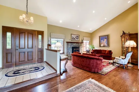a kitchen with stainless steel appliances kitchen island granite countertop a table chairs and a refrigerator