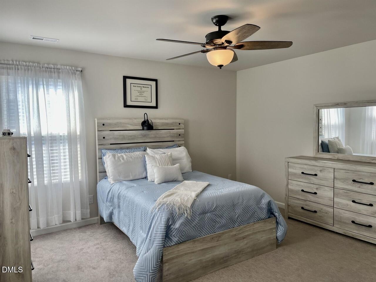 1807 Wrenn Road Durham, NC 27703 - Photo 35 of 43 a bedroom with a bed and a chandelier