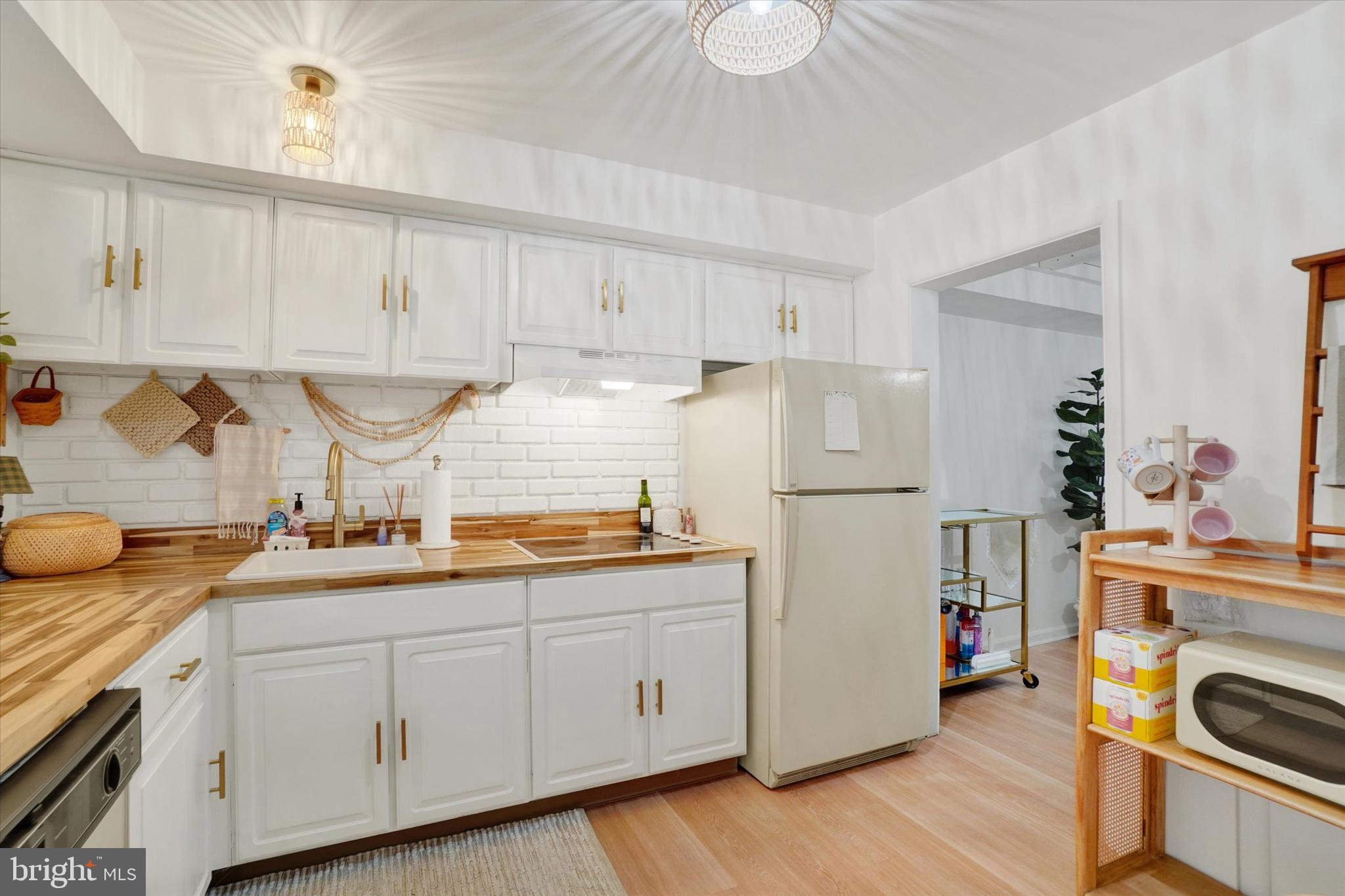 685 Colony Drive York, PA 17404 - Photo 5 of 26 a kitchen with a sink dishwasher stove and white cabinets with wooden floor