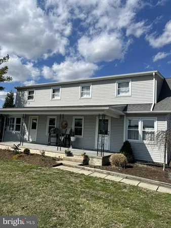 a front view of a house with swimming pool and furniture