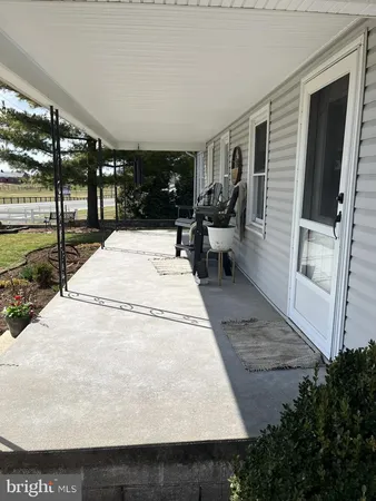 a view of a porch with furniture and floor to ceiling window