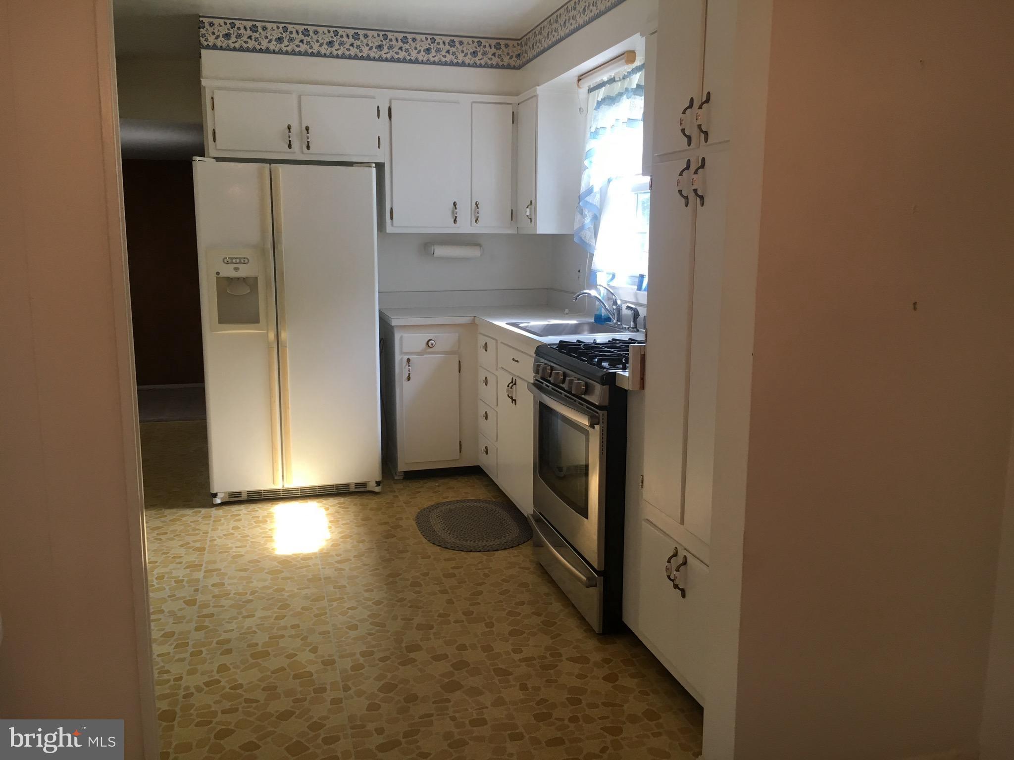 9003 Tammy Road Baltimore, MD 21236 - Photo 5 of 12 a kitchen with stainless steel appliances granite countertop a refrigerator a stove and a sink