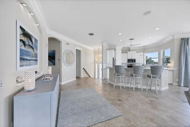 a kitchen with stainless steel appliances granite countertop a stove top oven a sink dishwasher a dining table and chairs with wooden floor