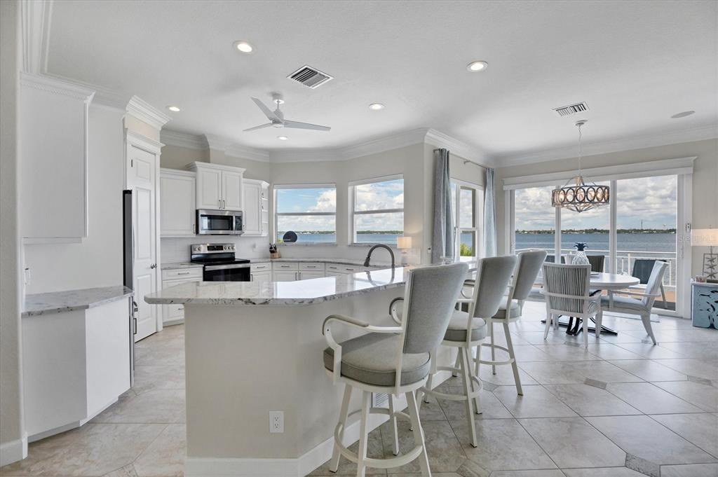 4111 North Beach Road Englewood, FL 34223 - Photo 22 of 87 a view of kitchen with stainless steel appliances refrigerator stove dining table and chairs