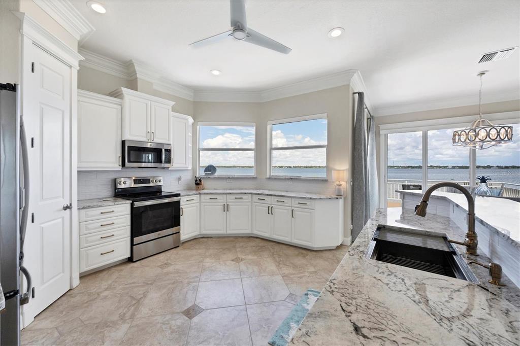 4111 North Beach Road Englewood, FL 34223 - Photo 26 of 87 a kitchen with granite countertop a sink stainless steel appliances and window