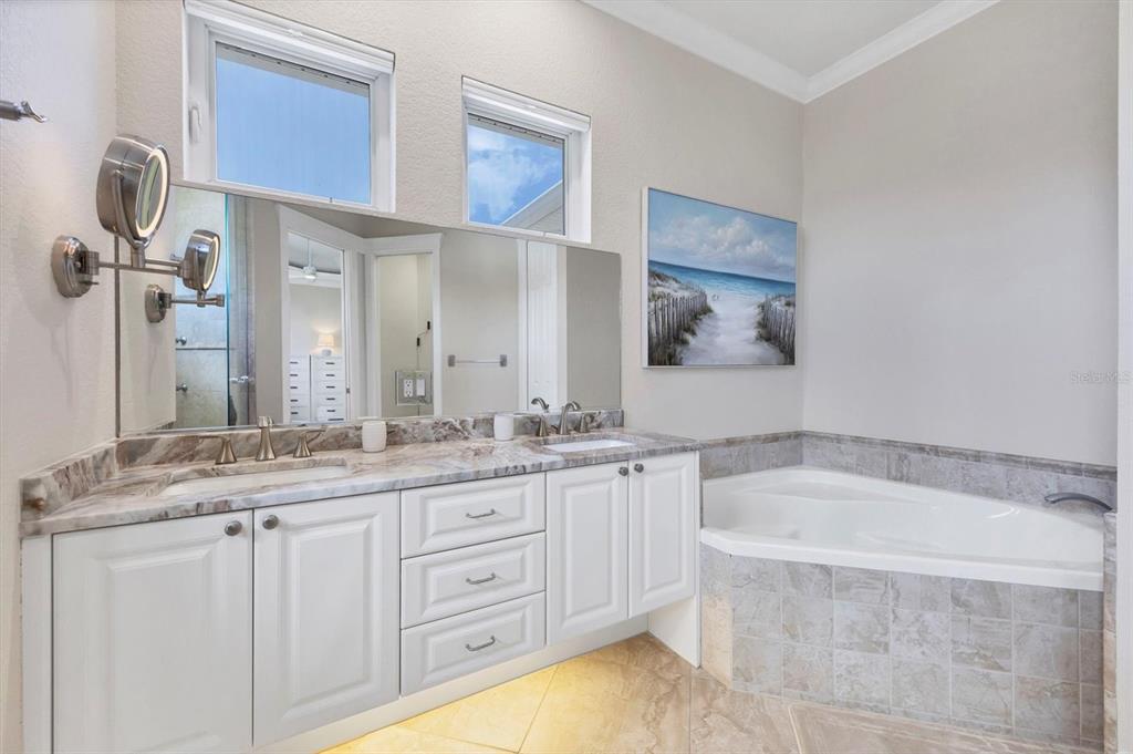 4111 North Beach Road Englewood, FL 34223 - Photo 36 of 87 a bathroom with a granite countertop bathtub sink and mirror
