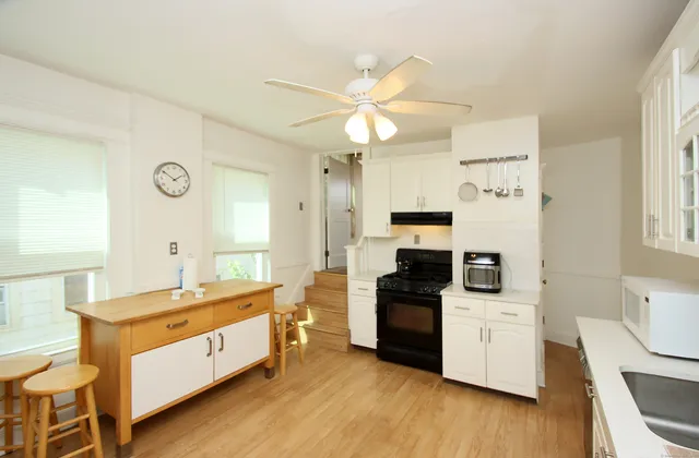 a kitchen with a sink cabinets and wooden floor