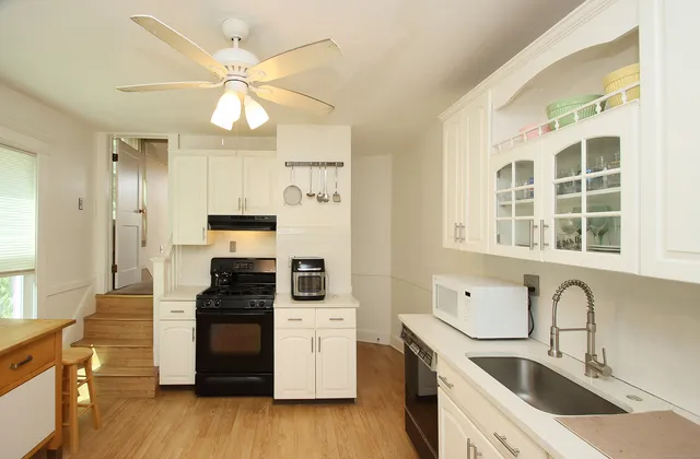 a kitchen with granite countertop a stove a sink and a refrigerator