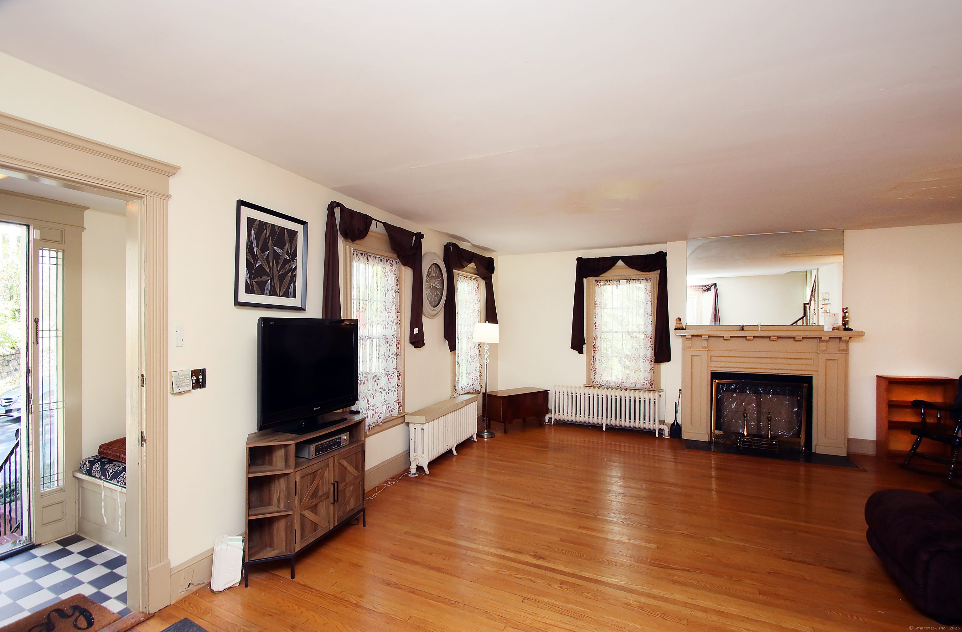 181 Buckingham Street Waterbury, CT 06710 - Photo 6 of 40 a living room with furniture a flat screen tv and a fireplace