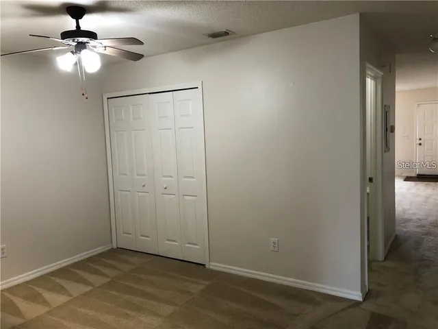 an empty room with fan and windows