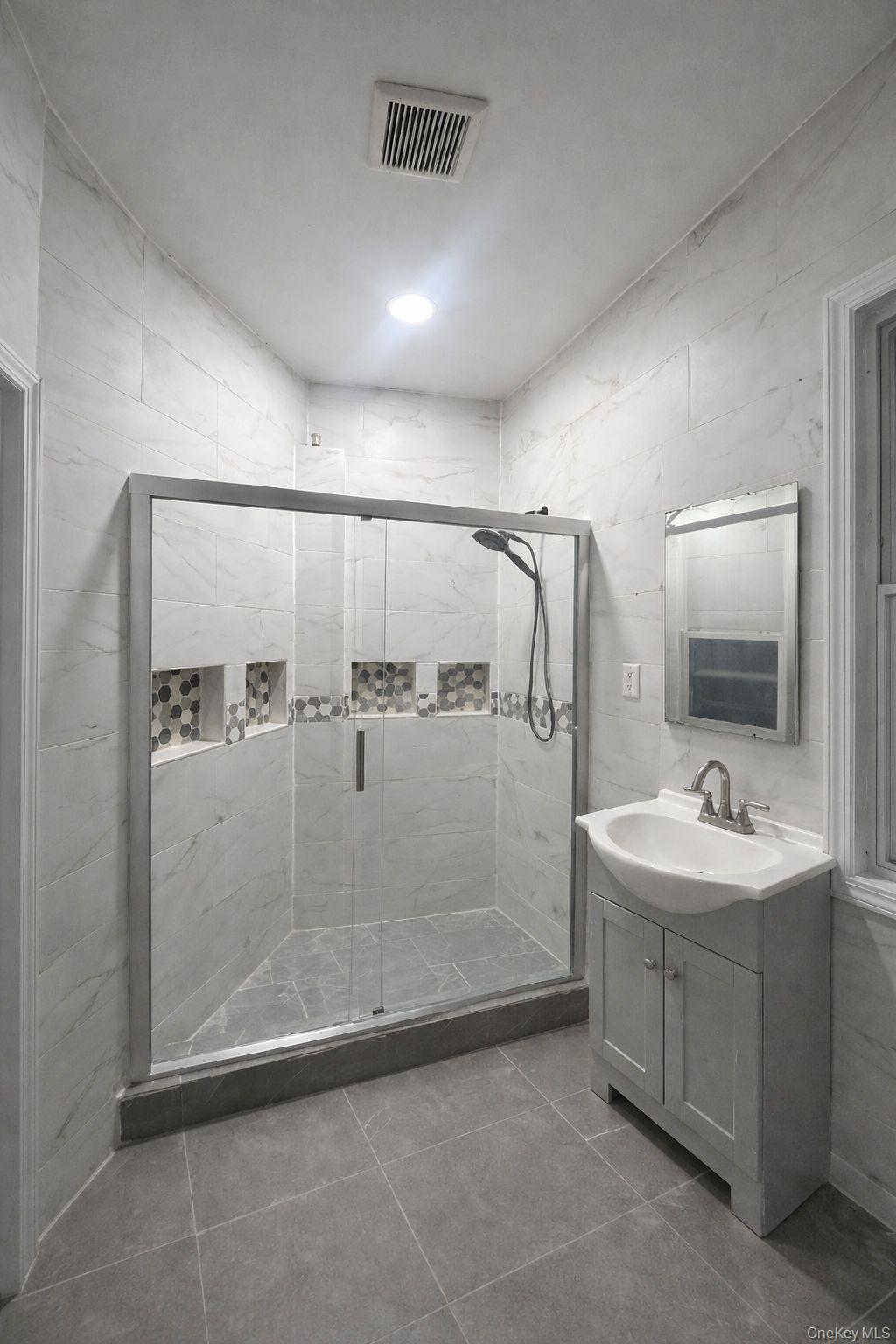 3581 Eastchester Road, Unit 2 Bronx, NY 10469 - Photo 12 of 13 a bathroom with a double vanity sink a mirror and shower