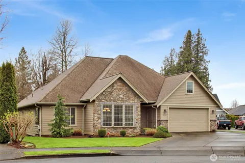 a view of a big house with wooden fence and large trees