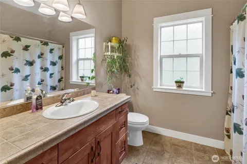 a bathroom with a granite countertop sink toilet and mirror