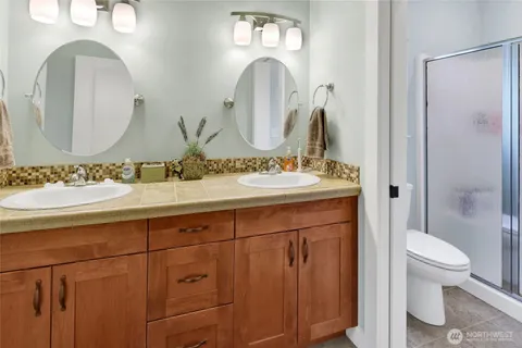 a bathroom with a double vanity sink toilet and a mirror
