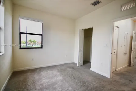 an empty room with a window and a ceiling fan