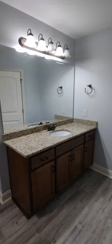 a bathroom with a granite countertop sink a mirror and vanity