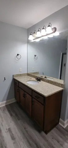 a bathroom with a granite countertop sink and mirror