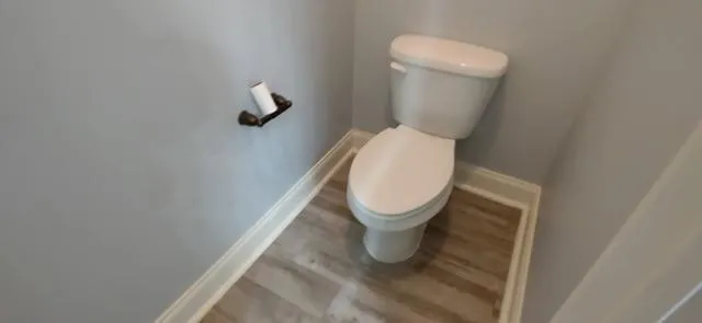 a white toilet sitting next to a white wall