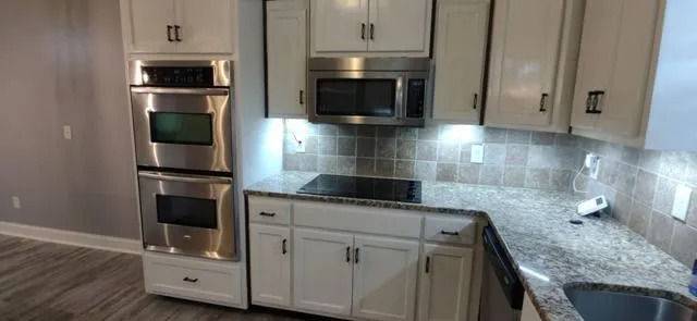 a kitchen with granite countertop a stove and a microwave