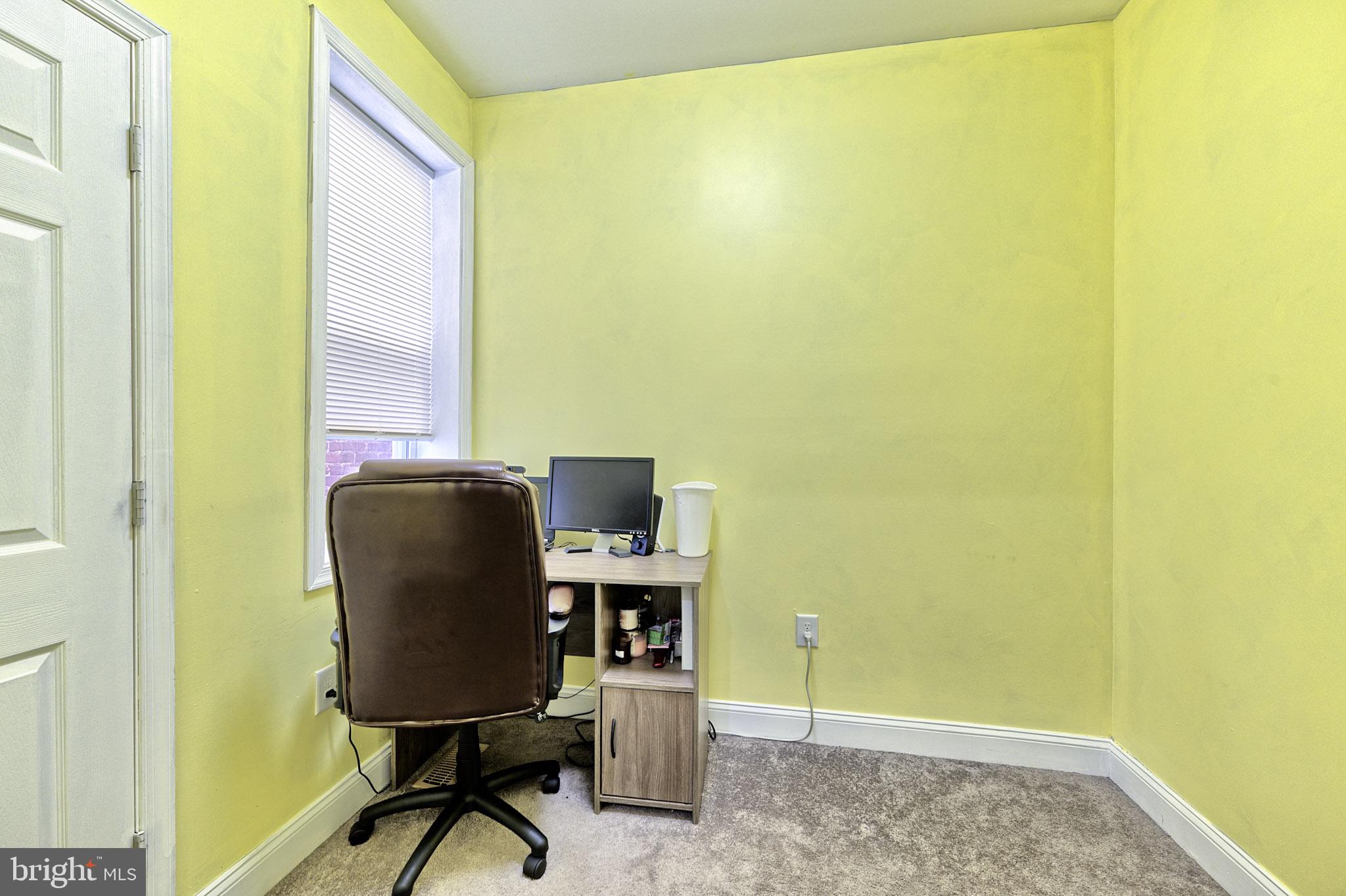 318 East 28th Street Baltimore, MD 21218 - Photo 12 of 20 a view of a workspace with furniture and a gate