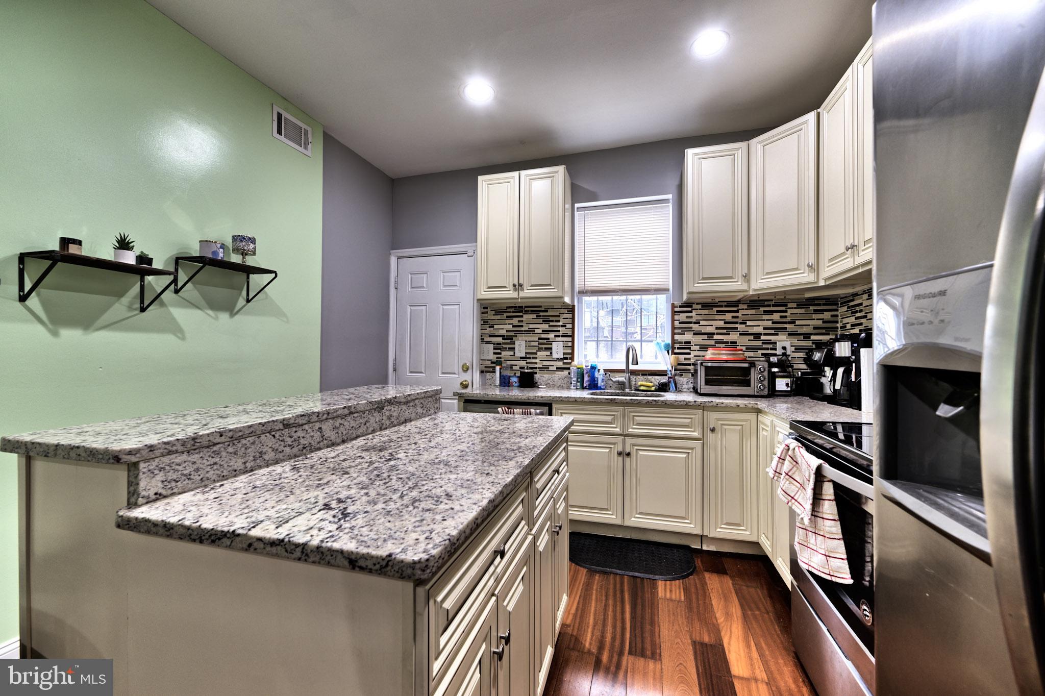 318 East 28th Street Baltimore, MD 21218 - Photo 6 of 20 a kitchen with granite countertop stainless steel appliances and white cabinets