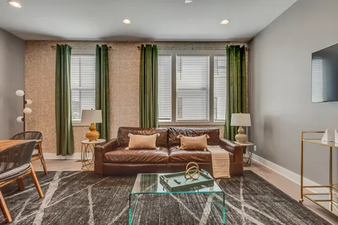 a living room with furniture a large window and a chandelier