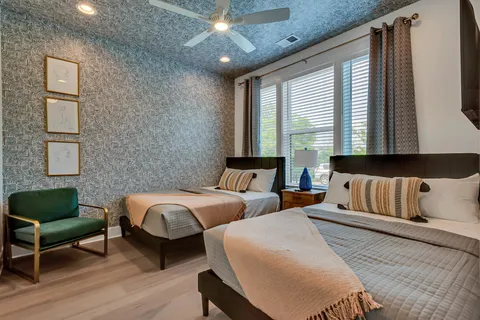 a bedroom with two beds and a flat screen tv