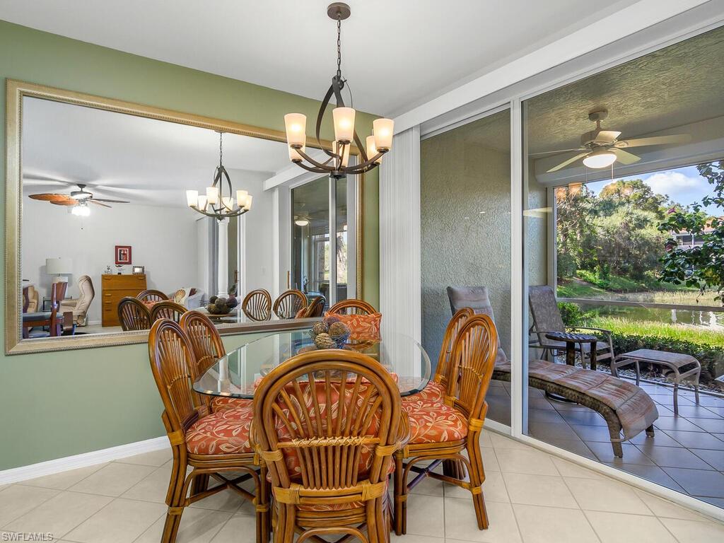 23831 San Marino Road, Unit 102 Estero, FL 34135 - Photo 14 of 39 Tiled dining room featuring a ceiling fan, plenty of natural light, and a chandelier