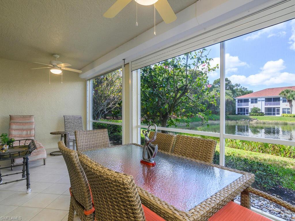23831 San Marino Road, Unit 102 Estero, FL 34135 - Photo 27 of 39 Sunroom with a textured wall, a water view, a textured ceiling, and tile patterned flooring