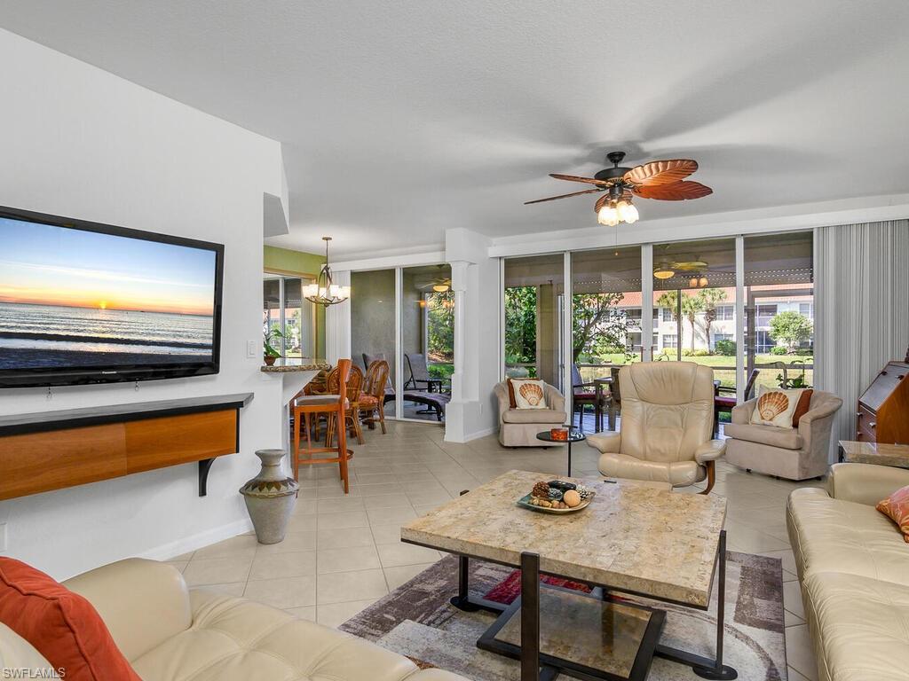 23831 San Marino Road, Unit 102 Estero, FL 34135 - Photo 5 of 39 Living room with a chandelier, light tile patterned floors, and ceiling fan